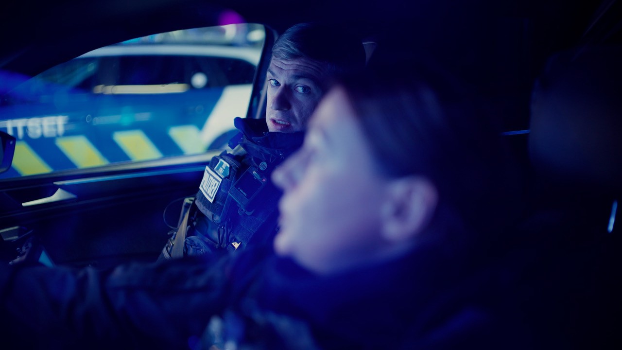 Politseinik vaatab autos enda kõrval istuvat kolleegi.