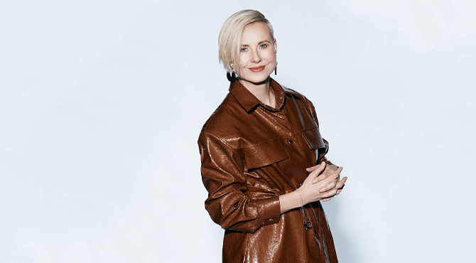 Naine TV3 Eesti saatest Laser, kandes pruuni mantlit valgel taustal.