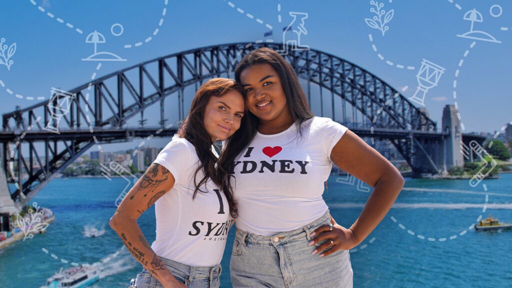kaks naist seisavad, valged särgid seljas, nende taga Austraalia sild