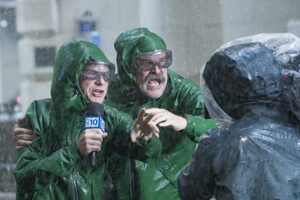 Kaks meest vestlevad rohelistes riietes ja sajab vihma
