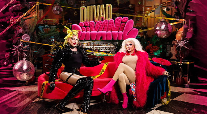 two men dressed as women on a sofa